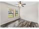 Bright bedroom with wood-look floors, ceiling fan and view to the front yard at 3548 E Mesquite St, Gilbert, AZ 85296