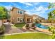 Backyard pool with lounge chairs and lush grass and a rock border around the pool at 3548 E Mesquite St, Gilbert, AZ 85296