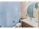 Stylish powder room featuring a vanity with a modern sink and a decorative round mirror at 3548 E Mesquite St, Gilbert, AZ 85296