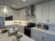 Well-lit kitchen featuring white cabinets, a modern range hood, and ample counter space at 3646 E Roland St, Mesa, AZ 85215