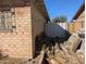 The exterior features a brick wall, yard debris, and a partial metal fence at 3932 W Bethany Home Rd, Phoenix, AZ 85019