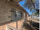 Side view showcasing brick facade and barred windows under clear blue skies at 3932 W Bethany Home Rd, Phoenix, AZ 85019