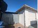 Garage with peeling paint and a corrugated metal fence against a blue sky at 3932 W Bethany Home Rd, Phoenix, AZ 85019