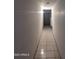 A long, empty hallway with tile flooring leading to a door at 3932 W Bethany Home Rd, Phoenix, AZ 85019