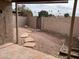 View of the backyard with a stone paver path, gravel, and block fence at 4107 E Charter Oak N Rd, Phoenix, AZ 85032