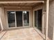 This covered patio features desert landscaping, a stone floor, and glass sliding doors at 4107 E Charter Oak N Rd, Phoenix, AZ 85032