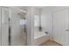 Clean bathroom featuring a shower with glass door and a soaking tub under a bright window at 43611 N 1St Dr, New River, AZ 85087