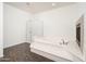 A bathroom with a glass-enclosed shower, a fireplace, and a large oval soaking tub at 4485 N 152Nd Dr, Goodyear, AZ 85395