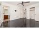 Bedroom featuring dark floors, a ceiling fan, and connected bathroom and closet spaces at 4485 N 152Nd Dr, Goodyear, AZ 85395