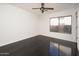 Minimalist bedroom with dark wood flooring, ample natural light, and a ceiling fan at 4485 N 152Nd Dr, Goodyear, AZ 85395