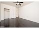 Bright bedroom features wood-look flooring, a ceiling fan, and a sliding door closet at 4485 N 152Nd Dr, Goodyear, AZ 85395