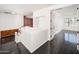 Spacious room featuring dark wood floors and white walls and a white handrail on the staircase at 4485 N 152Nd Dr, Goodyear, AZ 85395