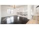 View of living room with black hardwood floors, chandelier, stairs, and many windows at 4485 N 152Nd Dr, Goodyear, AZ 85395