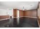 A spacious living room featuring dark wood floors, a ceiling fan, and a staircase at 4485 N 152Nd Dr, Goodyear, AZ 85395