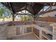 Outdoor kitchen features stainless steel appliances, a sink, and tile backsplash at 4485 N 152Nd Dr, Goodyear, AZ 85395