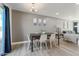 Light-filled dining room with a modern chandelier and adjacent living area at 4630 N 68Th St # 213, Scottsdale, AZ 85251