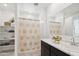 Bright bathroom featuring double sinks with modern fixtures, open shelving, and a shower with decorative curtain at 469 W Freedom St, Florence, AZ 85132