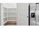 White, walk-in pantry features spacious shelving, adjacent to a stainless steel refrigerator at 469 W Freedom St, Florence, AZ 85132