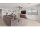 Comfortable living room featuring a plush sectional sofa, wall shelving, and large windows at 5325 N 188Th Ave, Litchfield Park, AZ 85340