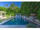 Exterior pool area with a jacuzzi, surrounded by lush greenery and an outdoor seating area at 5819 E Calle Del Media --, Phoenix, AZ 85018