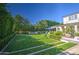 Backyard putting green area, surrounded by trees, and a two-story house in the background at 5819 E Calle Del Media --, Phoenix, AZ 85018