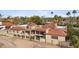 Aerial view of a luxurious home with a red tile roof, lush landscaping, and a sparkling backyard pool at 5827 E Sanna St, Paradise Valley, AZ 85253