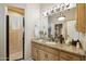 Well-appointed bathroom featuring a granite countertop, wood cabinetry, and tiled shower at 5827 E Sanna St, Paradise Valley, AZ 85253