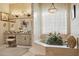 Elegant bathroom featuring a soaking tub, decorative wallpaper, and vanity with a mirror at 5827 E Sanna St, Paradise Valley, AZ 85253