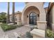 Ornate double doors under an arched entranceway, framed by meticulously maintained landscaping and stone accents at 5827 E Sanna St, Paradise Valley, AZ 85253