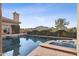 Inviting pool with rock accents surrounded by lush greenery and view of mountain in background at 5827 E Sanna St, Paradise Valley, AZ 85253