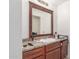 Bathroom with a light colored countertop and dark wooden cabinets, and dark framed mirror at 5952 W Coronado Rd, Phoenix, AZ 85035