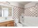 Bathroom features a tiled shower-tub and a wooden sink vanity at 5952 W Coronado Rd, Phoenix, AZ 85035