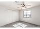 Bedroom features tile flooring, neutral paint throughout, closet, and a ceiling fan at 5952 W Coronado Rd, Phoenix, AZ 85035