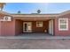 Covered patio featuring brick floors, exterior lighting, and access doors into the home at 5952 W Coronado Rd, Phoenix, AZ 85035