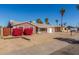 View of the home with a simple front yard, palm trees, and desert landscaping at 5952 W Coronado Rd, Phoenix, AZ 85035