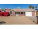 Charming single-story home with desert landscaping, a garage, and vibrant red bougainvillea bushes at 5952 W Coronado Rd, Phoenix, AZ 85035