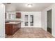 Kitchen with a breakfast bar, tile flooring, brown cabinets, white appliances and double glass doors at 5952 W Coronado Rd, Phoenix, AZ 85035