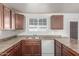 An eat-in kitchen features wood cabinets, light countertops, stainless steel sink, and a dishwasher at 5952 W Coronado Rd, Phoenix, AZ 85035