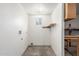 A bright laundry room with a small window, shelf, and utility connections ready for appliances at 5952 W Coronado Rd, Phoenix, AZ 85035