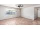 Bright living room with neutral walls, tiled floors, ceiling fan, and window at 5952 W Coronado Rd, Phoenix, AZ 85035