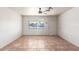 Bright living room with neutral walls, tiled floors, ceiling fan, and window at 5952 W Coronado Rd, Phoenix, AZ 85035