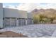 Three-car garage with wooden doors and patterned stone driveway, set against a mountain backdrop at 6038 E Agave Cir, Carefree, AZ 85377