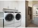 Bright laundry room with modern washer and dryer and convenient storage at 6038 E Agave Cir, Carefree, AZ 85377