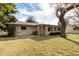 View of the home's back exterior, a small patio, and mature landscaping at 628 Leisure World --, Mesa, AZ 85206