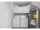 Functional laundry area featuring a washer, dryer, water heater, and upper storage cabinets at 628 Leisure World --, Mesa, AZ 85206