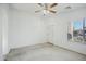 A simple, spacious bedroom with neutral carpet, a ceiling fan, and a window at 7557 W Colter St, Glendale, AZ 85303