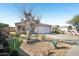 Street view of single story home featuring xeriscaping, mature tree, and attached garage at 7557 W Colter St, Glendale, AZ 85303