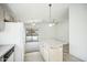 Open kitchen featuring white appliances and a central island, seamlessly connected to the living area at 7557 W Colter St, Glendale, AZ 85303