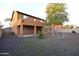 Large backyard with an orange tree, small rock ground cover, and a covered patio at 8776 W Peppertree Ln, Glendale, AZ 85305