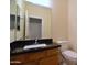 Bathroom features a modern vanity with a granite countertop and a large mirror at 8776 W Peppertree Ln, Glendale, AZ 85305